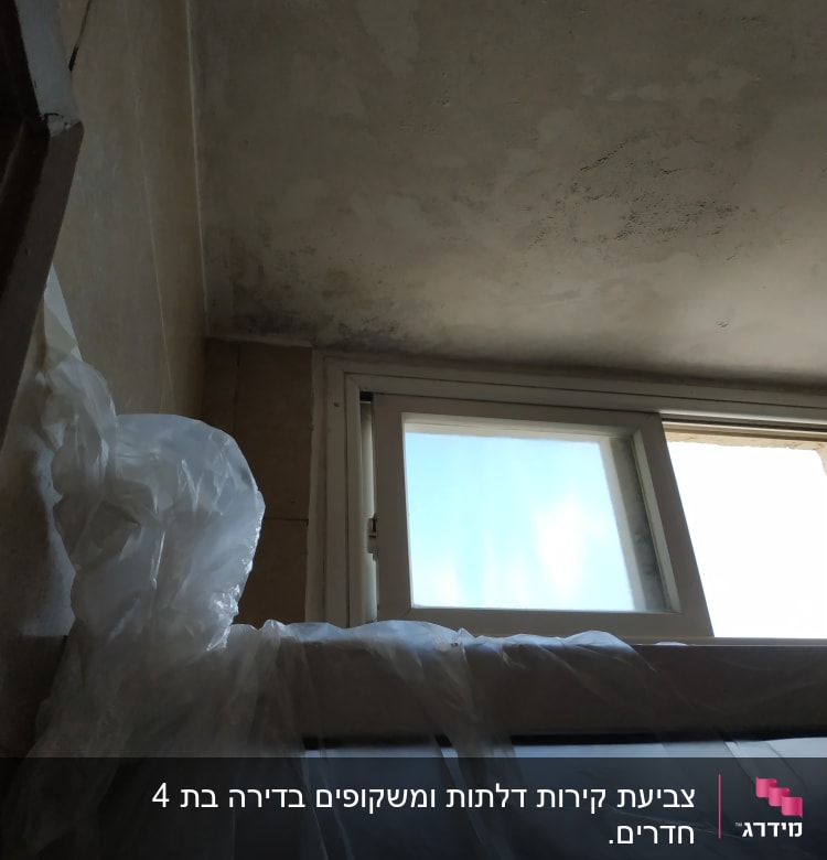 תקרה עם סימני רטיבות ויריעות פלסטיק לכיסוי